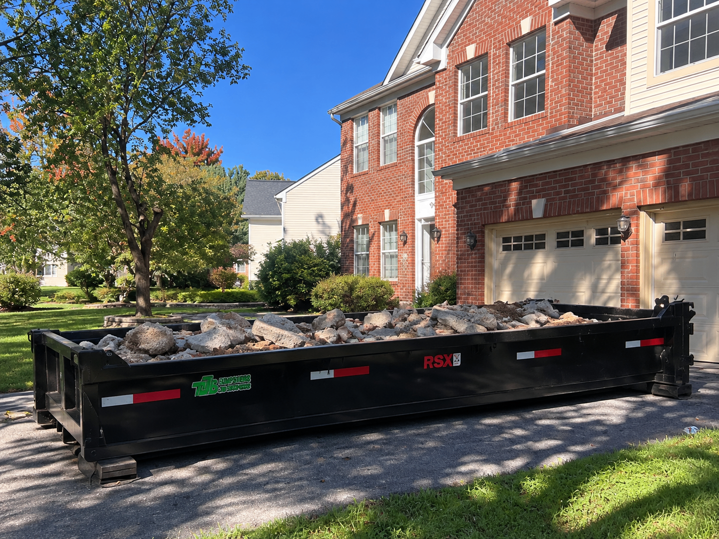 A Bin & Gon heavy material container filled with broken concrete outside a Maryland home